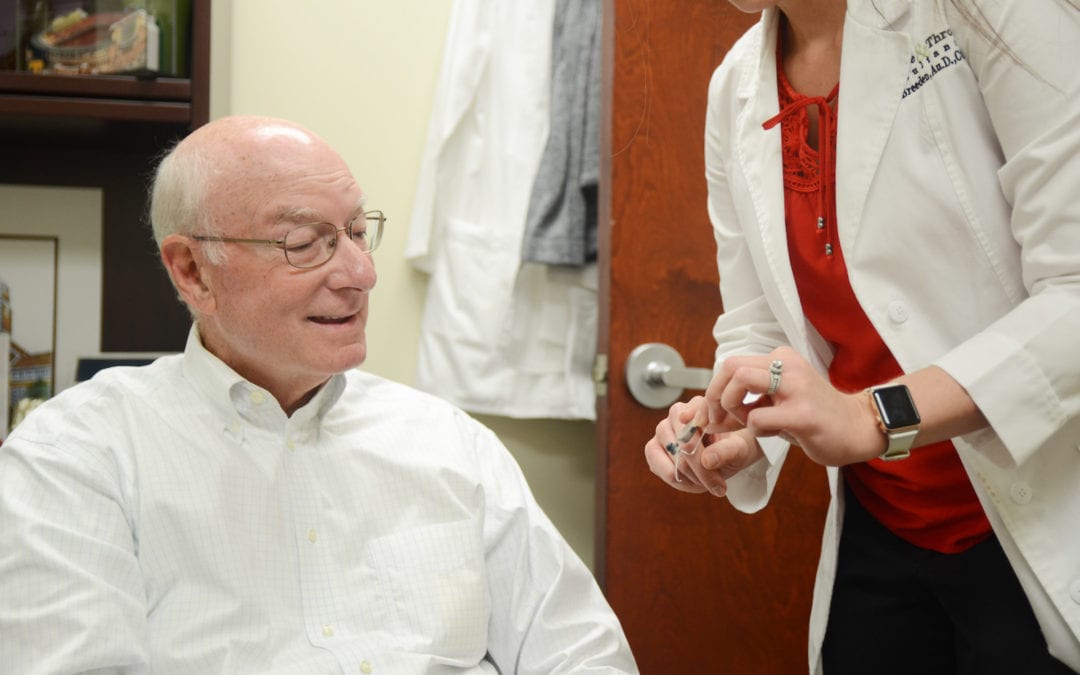patient looking at hearing aids | PHC Tennessee